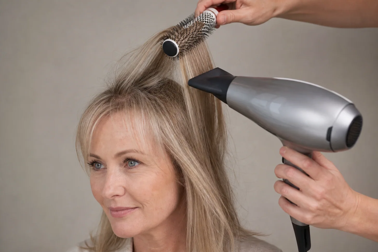 Round-brushing a lifted section of fine hair over-directed from the root for volume