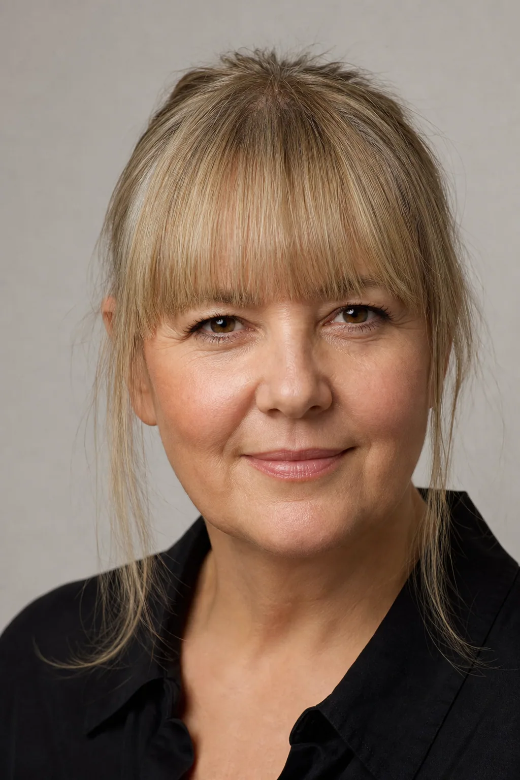 Straight-across blunt fringe shown as the shape to avoid, hard horizontal line across the forehead on fine hair, woman with a round face