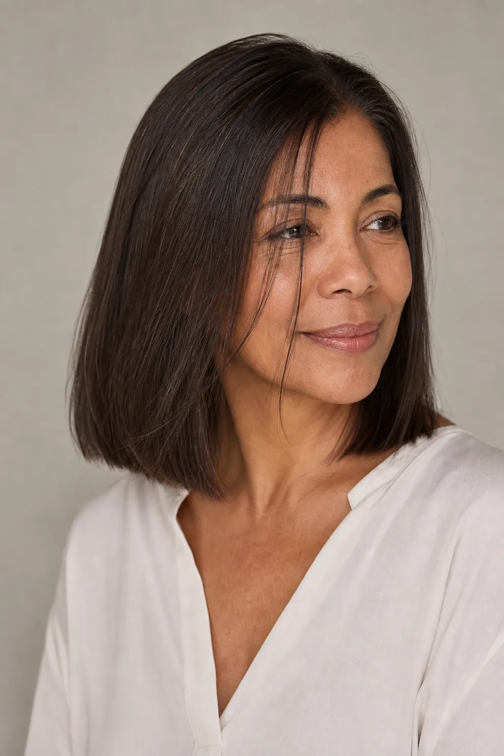 Collarbone-length fine hair with ghost layers, blunt ends, visible body through the mid-lengths, three-quarter view