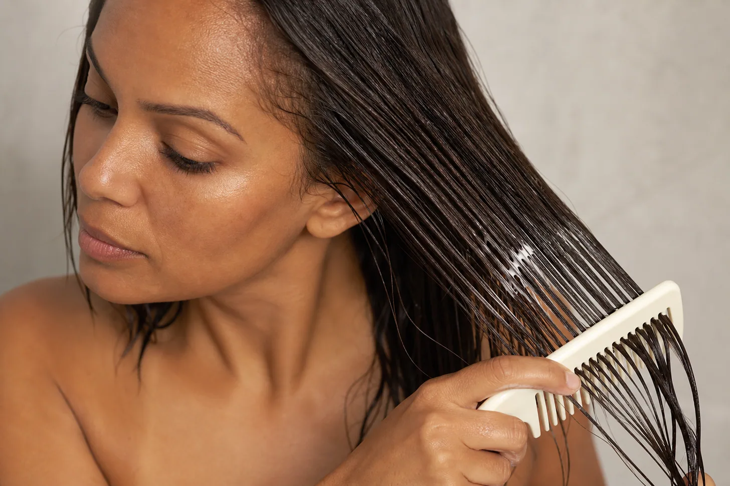Lightweight conditioner combed through the mid-lengths and ends of fine wet hair