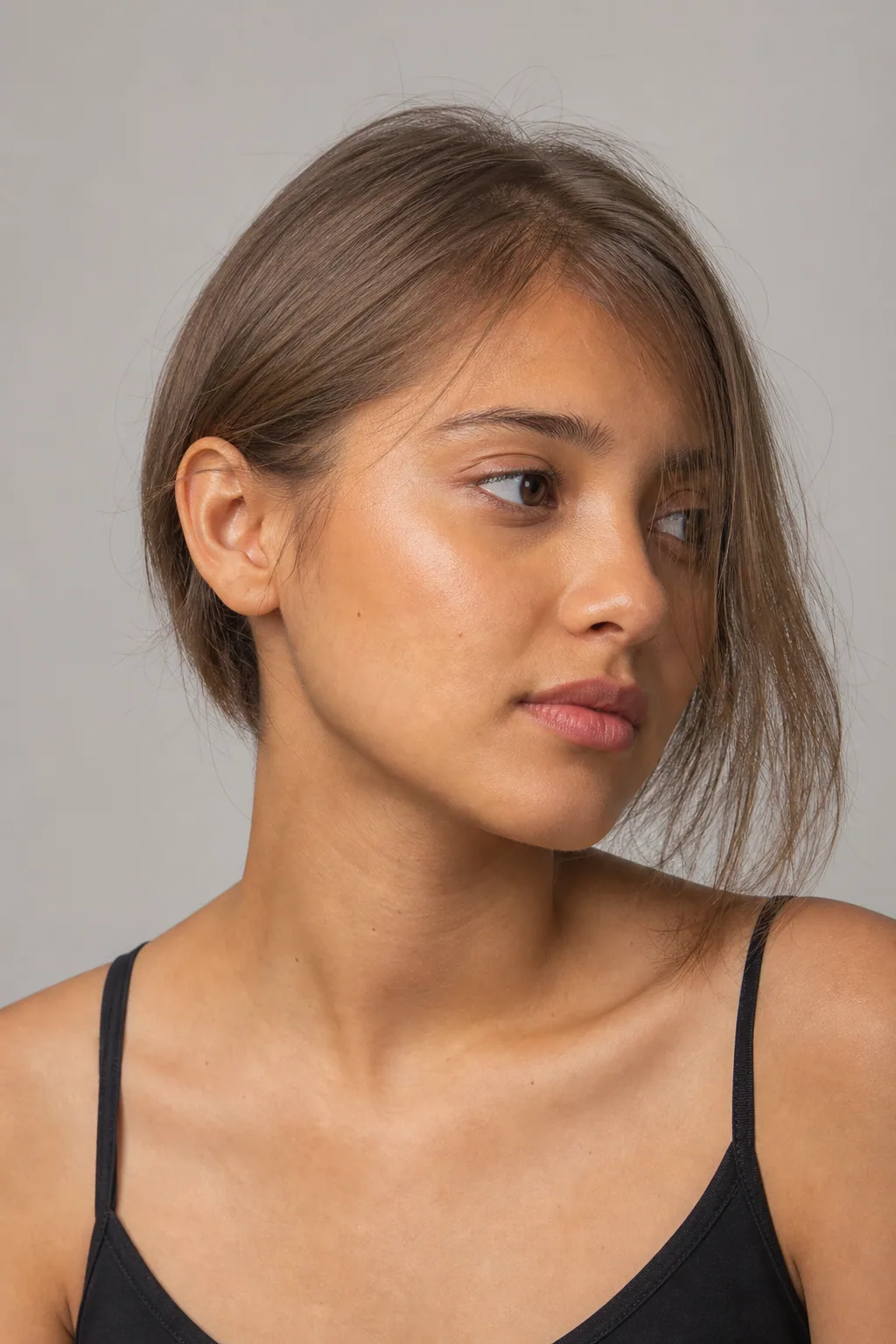 Ear-length fine hair tucked behind one ear, the other side left forward, three-quarter view