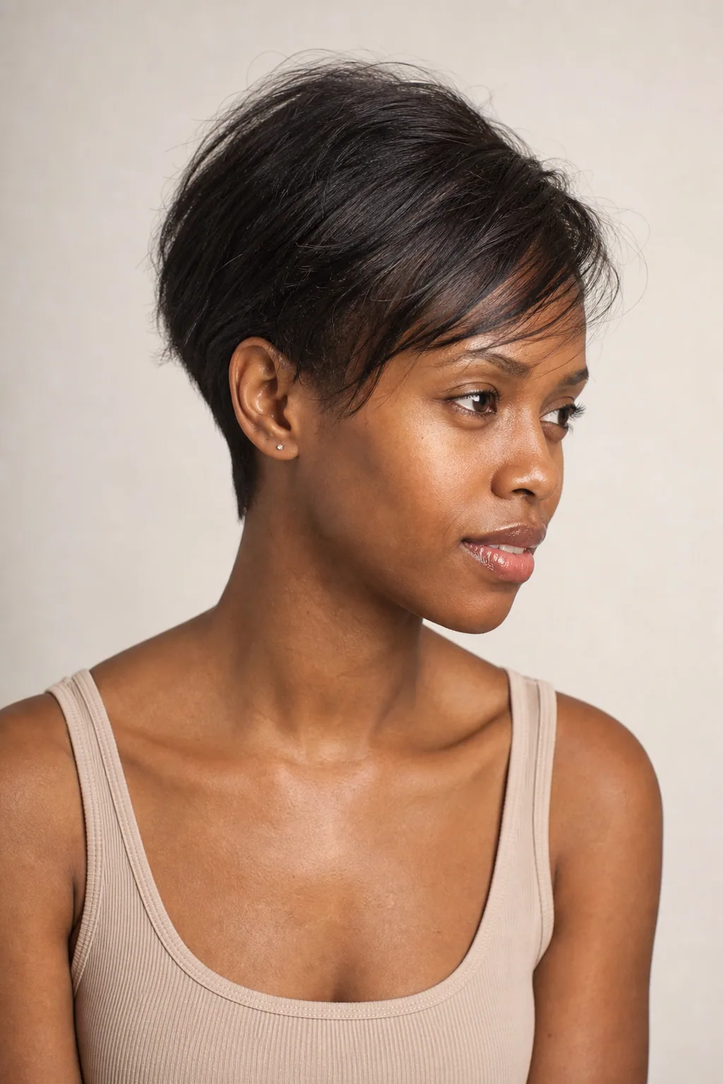 Grown-out fine pixie with a longer top swept to one side and a tidy nape, three-quarter view, natural daylight