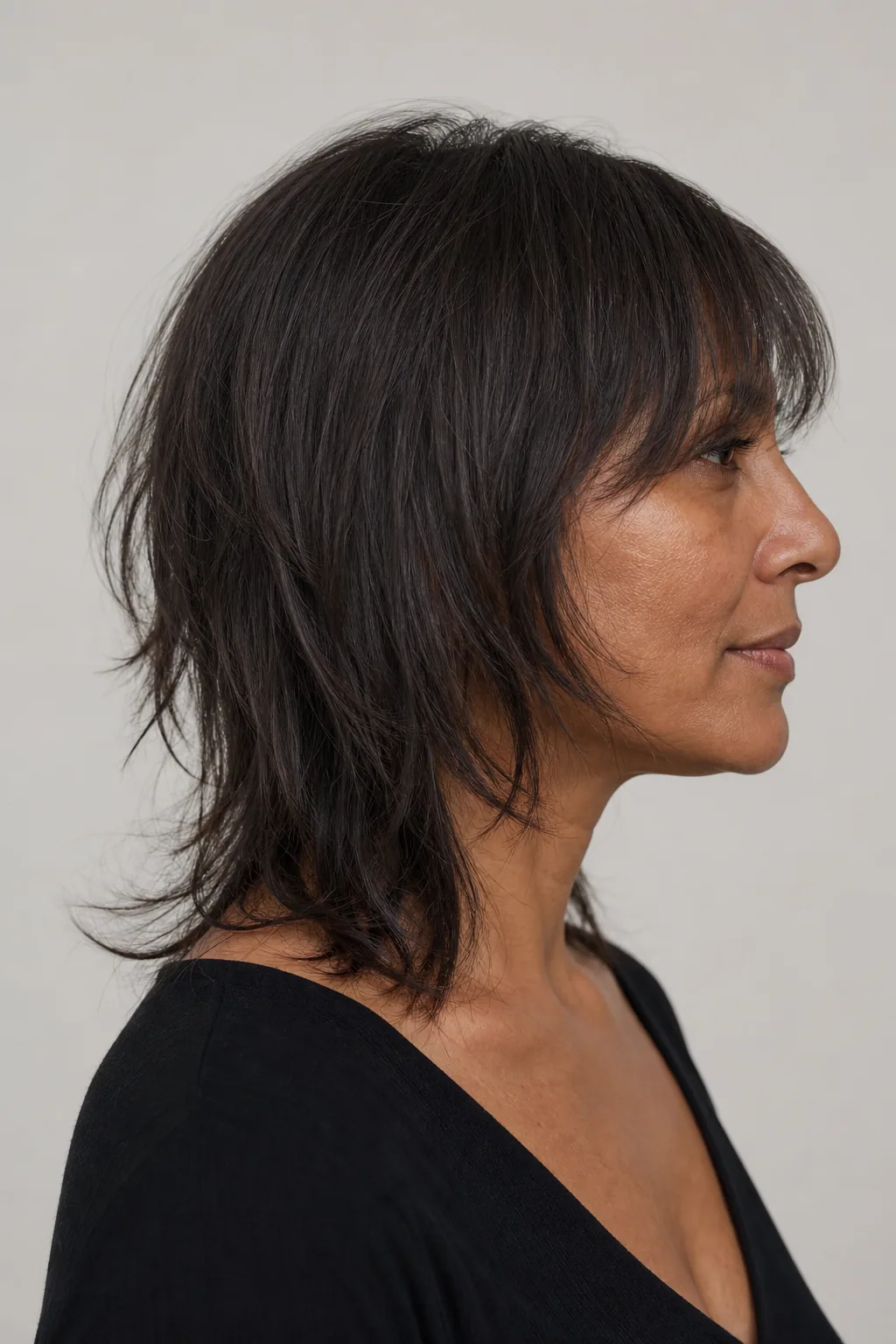 Grown-out transitional mullet on fine hair, softened layers reading as a shag, side view