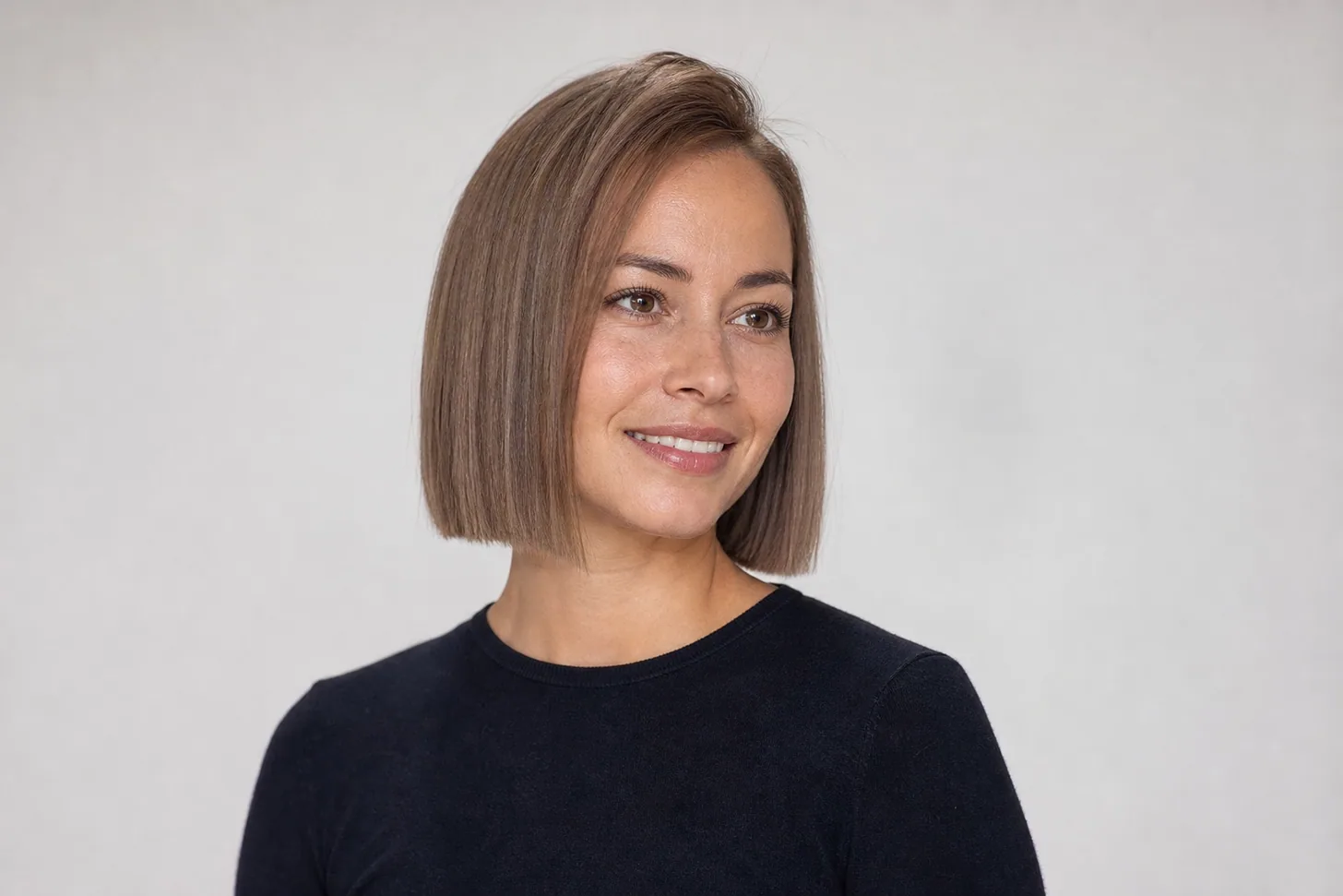 Blunt chin-length bob on fine straight light-brown hair with a solid hem