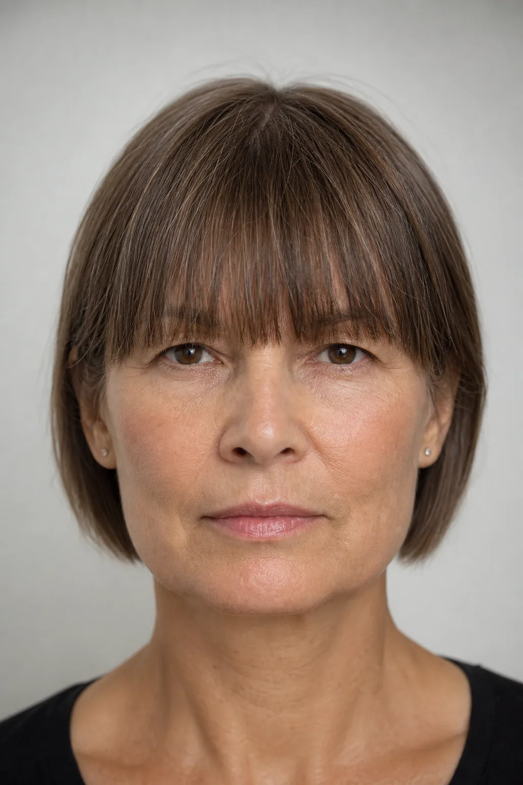 Fine hair with a heavy straight-across fringe level at the brow above a square jaw, front view showing two parallel horizontals
