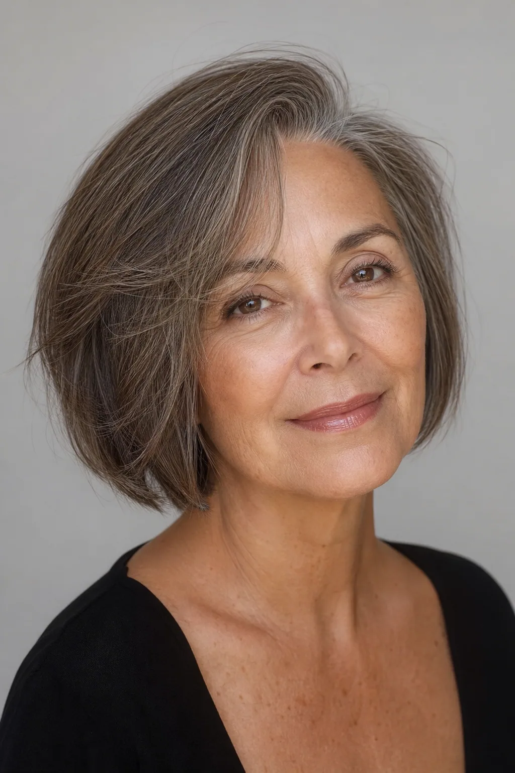 Jaw bob with a deep side part lifting the roots on fine thin brunette-grey hair over 60