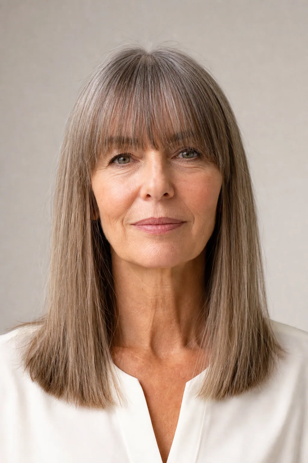 Long fine hair worn with a full brow-length fringe and blunt ends, long face, front view