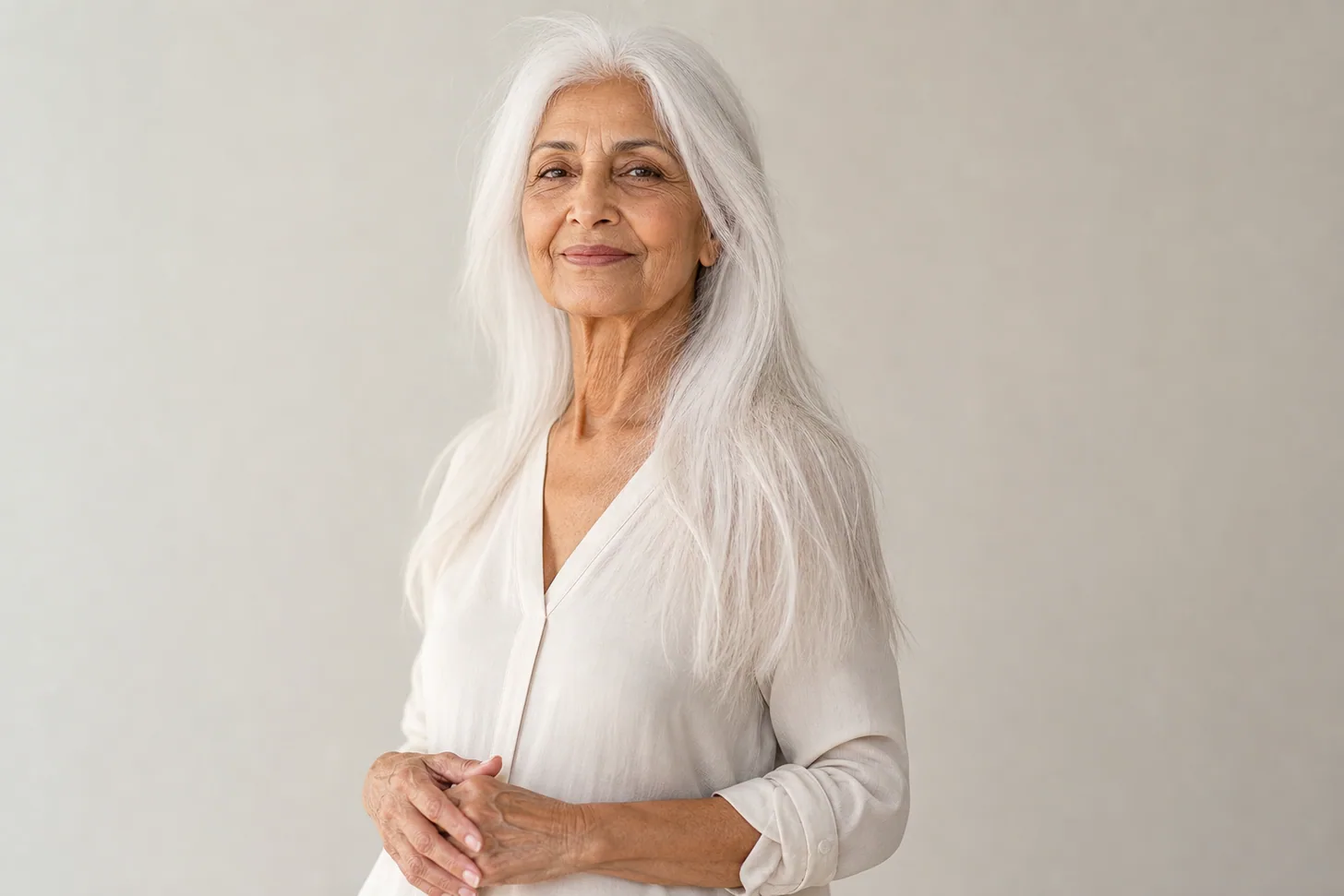 A woman in her seventies with long white hair, blunt ends and lift at the crown