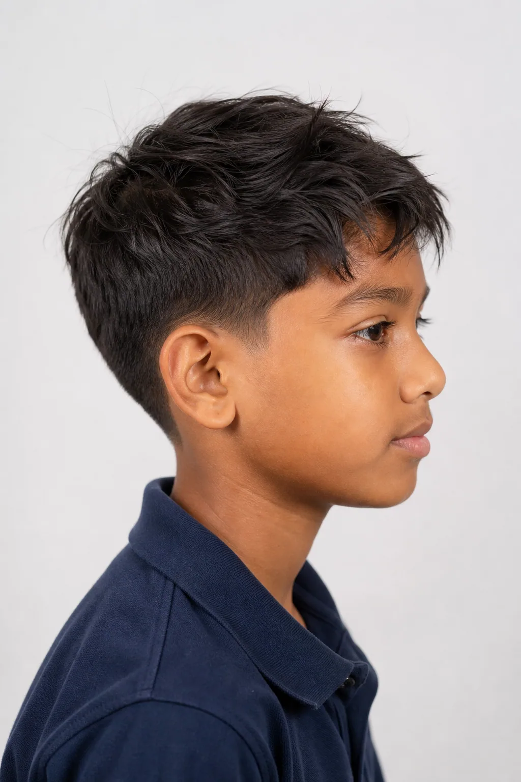 Eleven-year-old boy with a low taper and a messy textured top on thin hair
