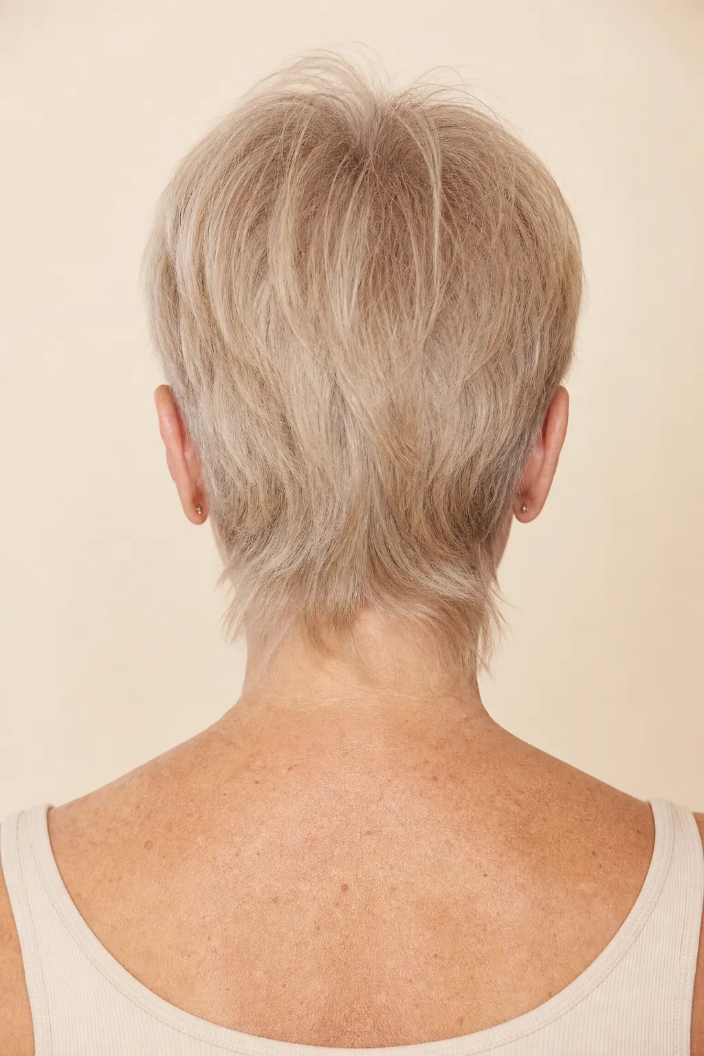Nape-length mullet on fine grey-blonde hair, shortest at the sides, back view showing the connected blend