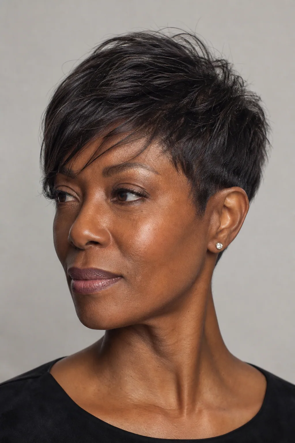 Pixie cut on fine hair with a long top section swept diagonally across the forehead, three-quarter view