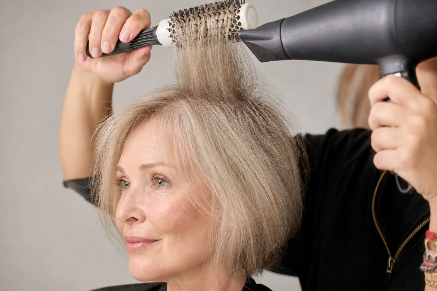 Round-brushing a crown section of fine hair over-directed straight up for root lift
