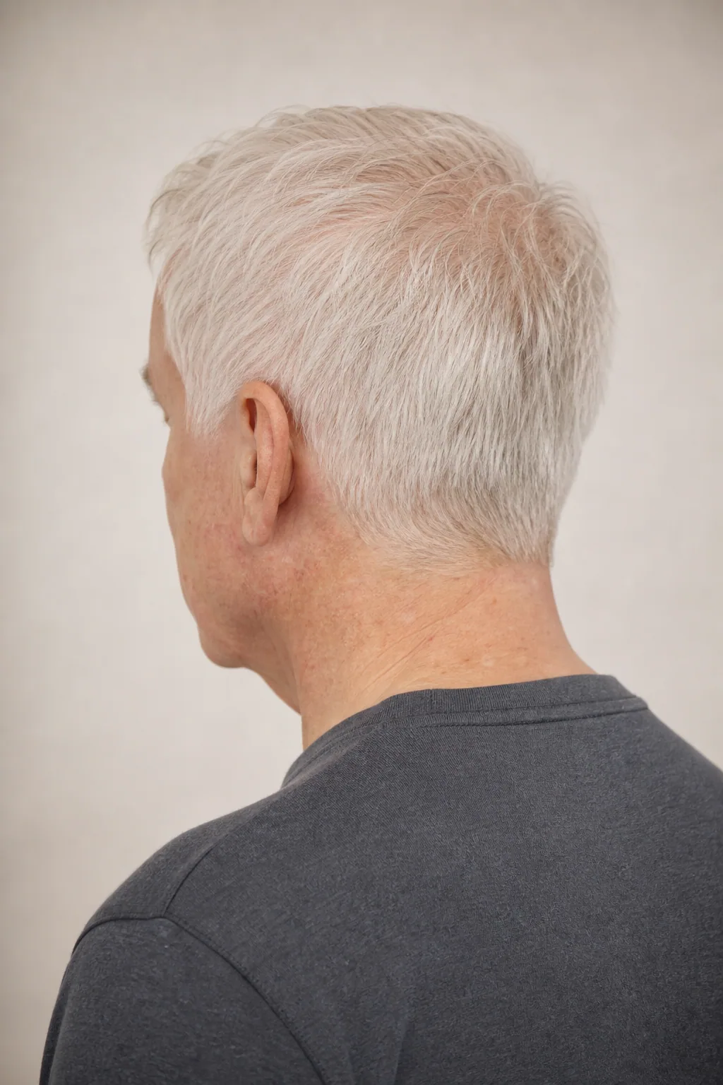 Short all-scissor cut on a man in his late sixties with thinning white hair