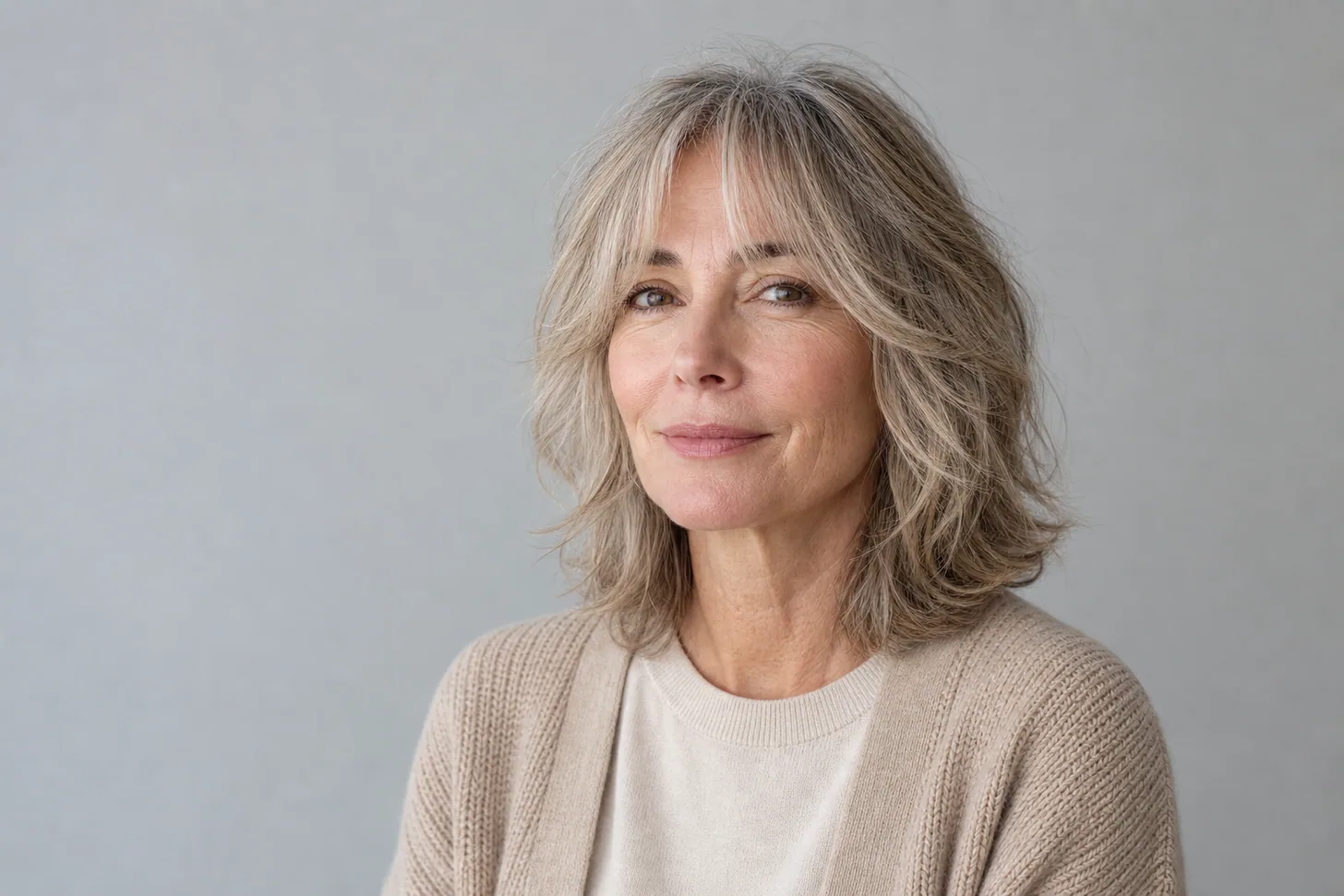 Soft shoulder-length shag with a curtain fringe on fine ash-blond hair over 50