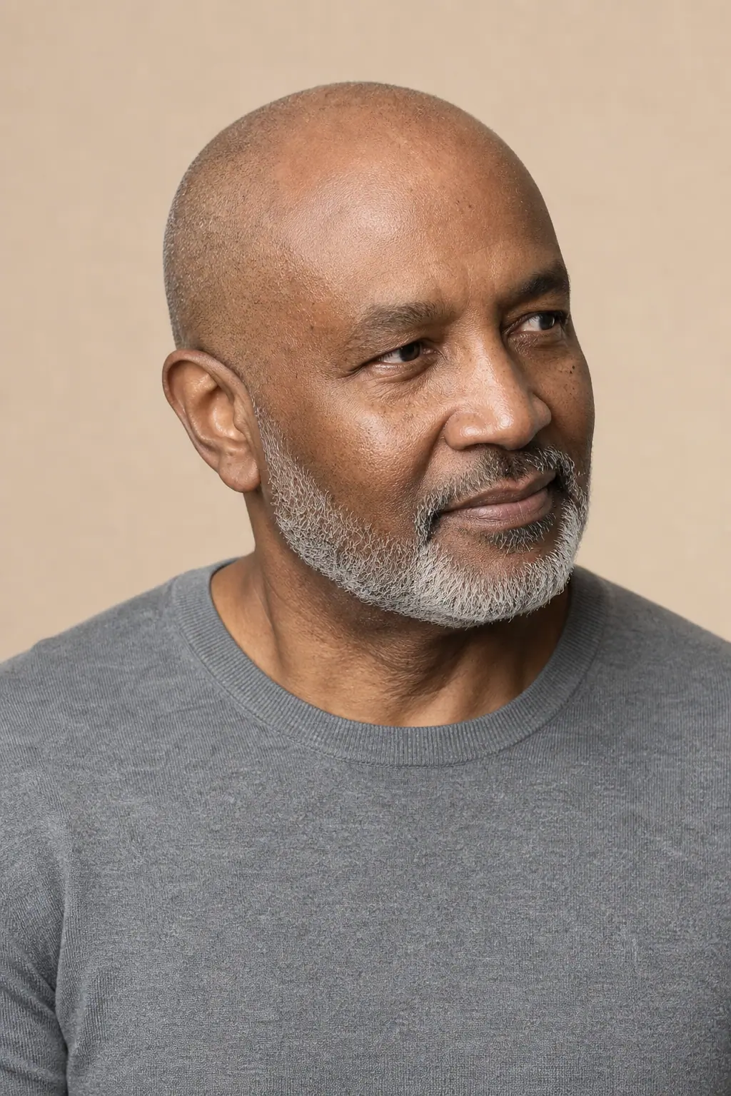 Clean shaved head with a short grey beard on a man in his fifties