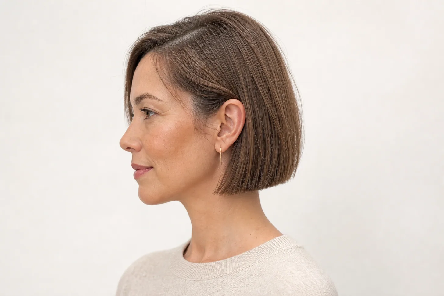 Short bob ending just below the earlobe on fine light-brown hair