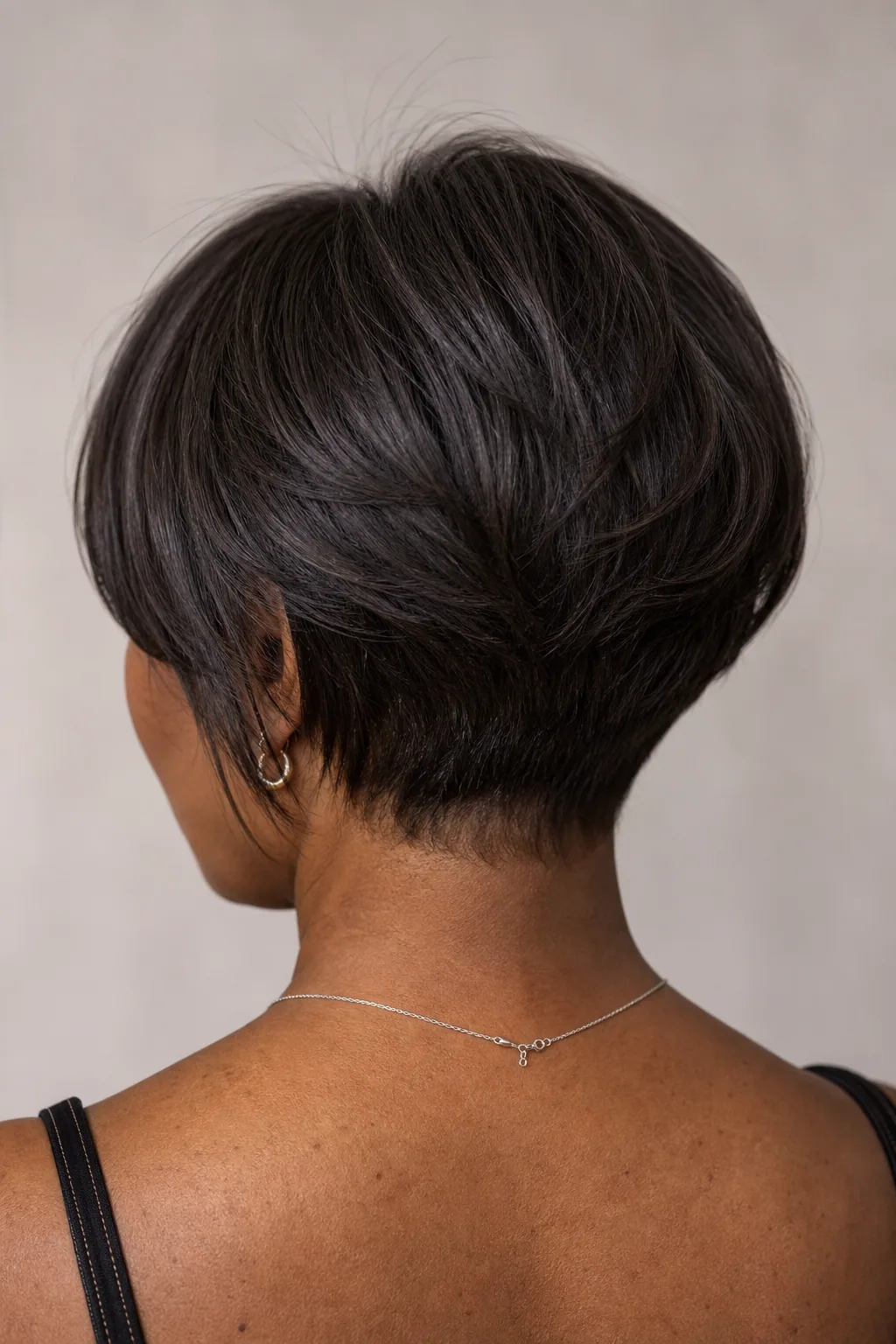 Back view of a short stacked bob on fine straight hair showing graduation and stacked nape building crown height