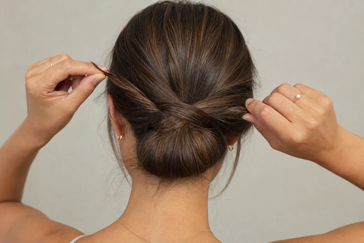 Twisted sections of fine hair wrapped around the base into a low bun