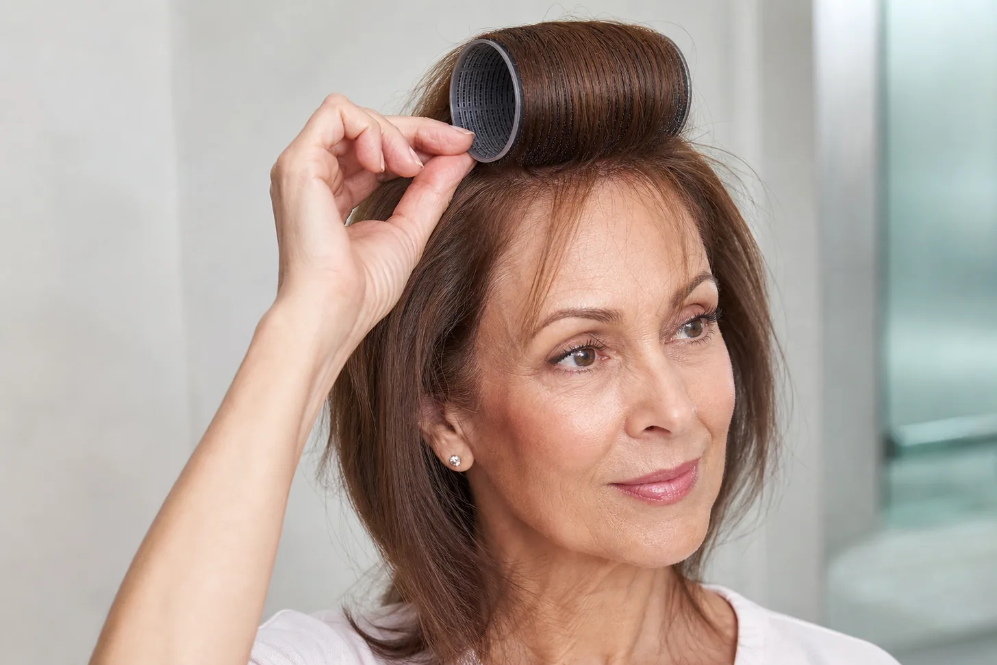 A large velcro roller set at the crown of fine hair for a morning root re-lift
