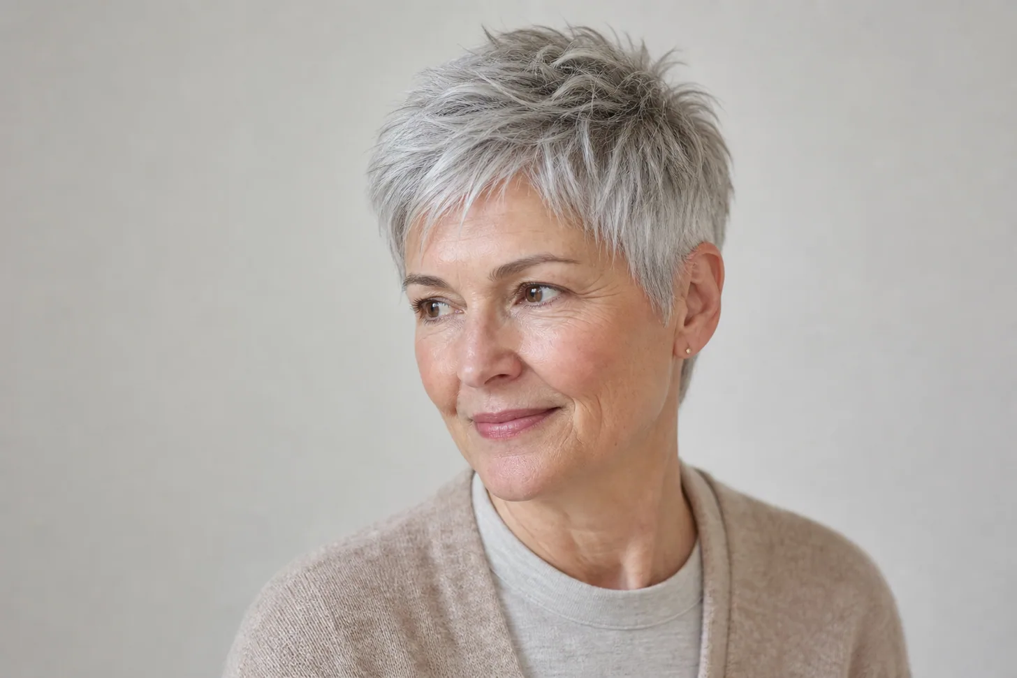 Soft air-dried pixie on fine silver hair, a wash-and-wear cut over 60