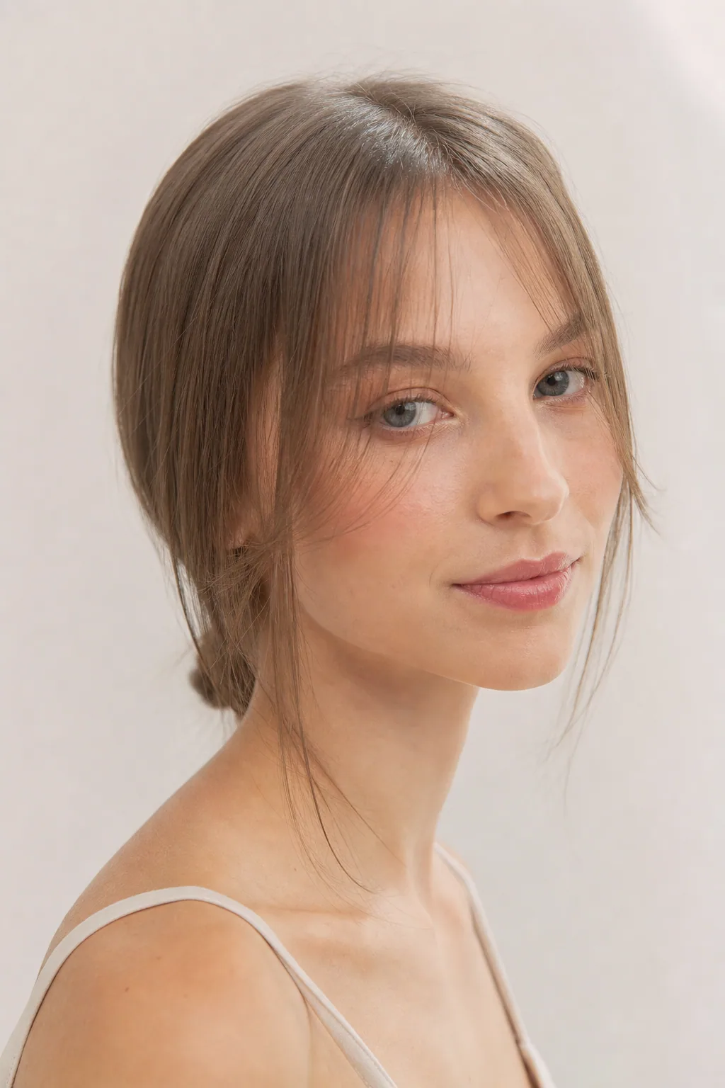 Wispy feathered cheekbone-length curtain bangs adding soft movement on fine straight hair